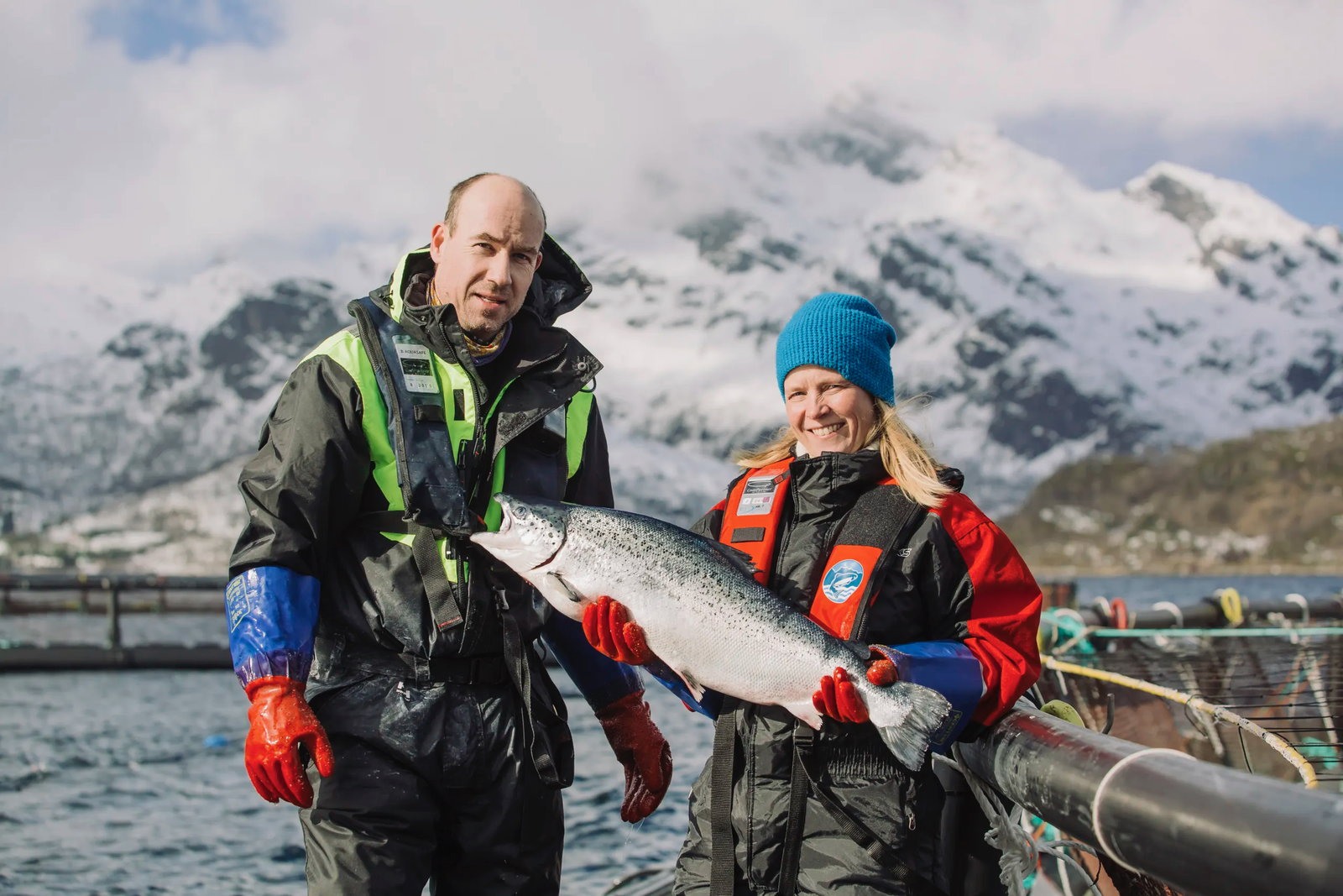 Man woman holding farmed salmon xxlofoten